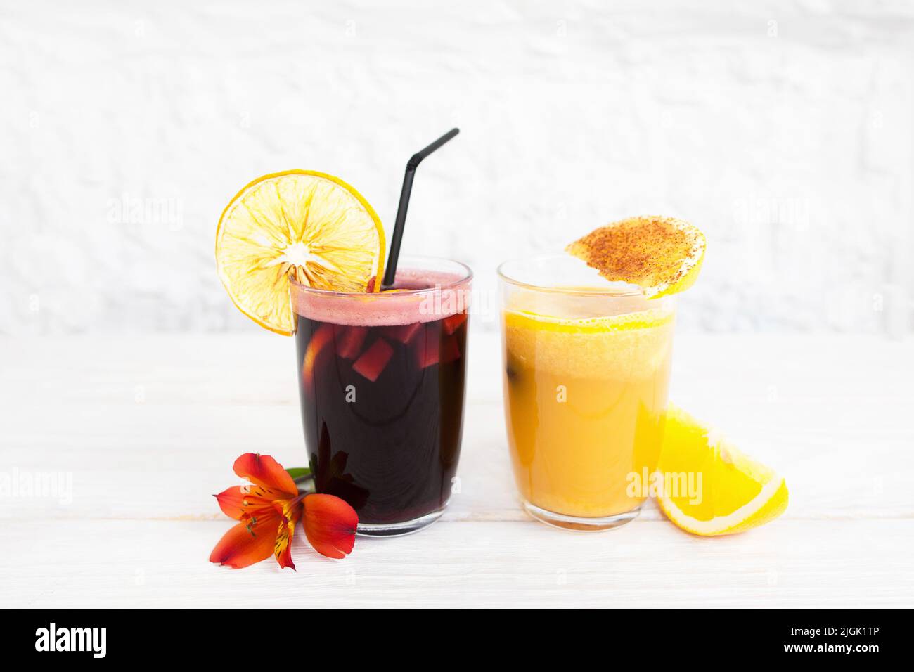 Punch and orange juice glasses on white background Stock Photo Alamy