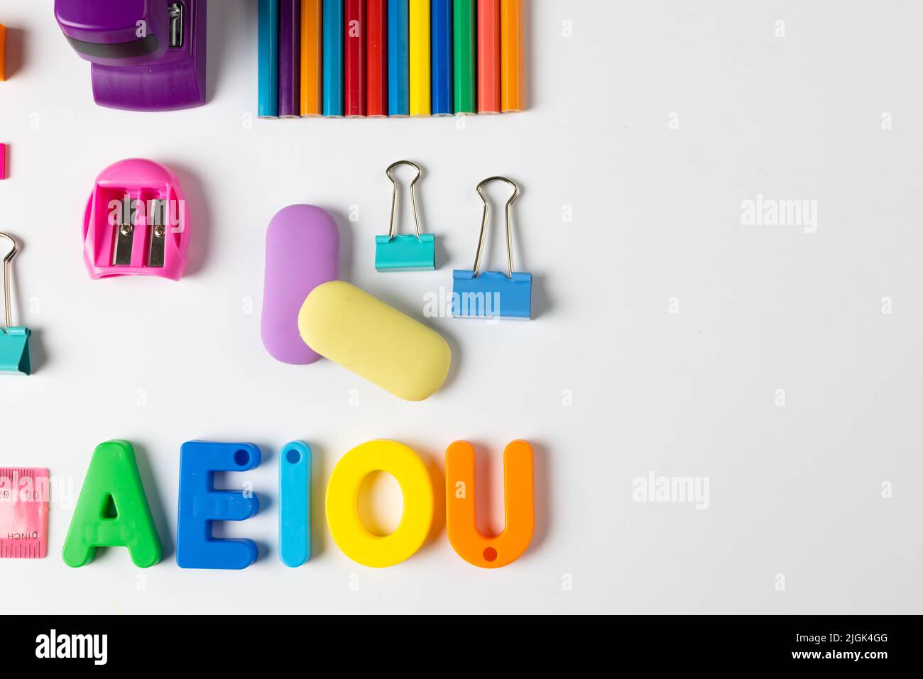 Composition of colorful school equipment with letters and clips on white surface Stock Photo