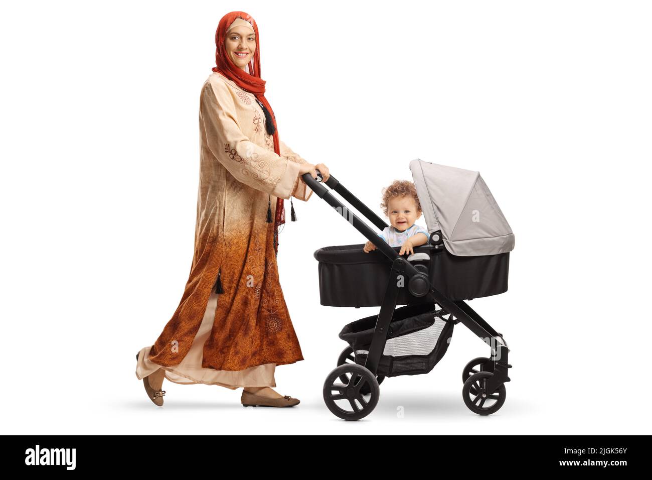 Full length shot of a young mother in ethnic clothes with hijab pushing a baby boy in a stroller isolated on white background Stock Photo