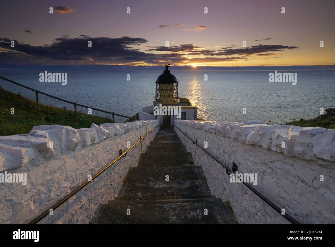 St Abbs lighthouse at sunrise with golden hour light. located in Berwickshire, Scottish borders, Scotland. Stock Photo