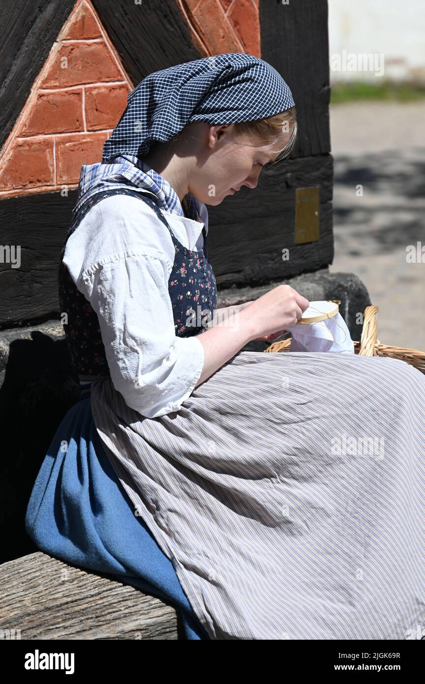 Reenactment: Young woman in the clothes of a 19th century maid Stock Photo