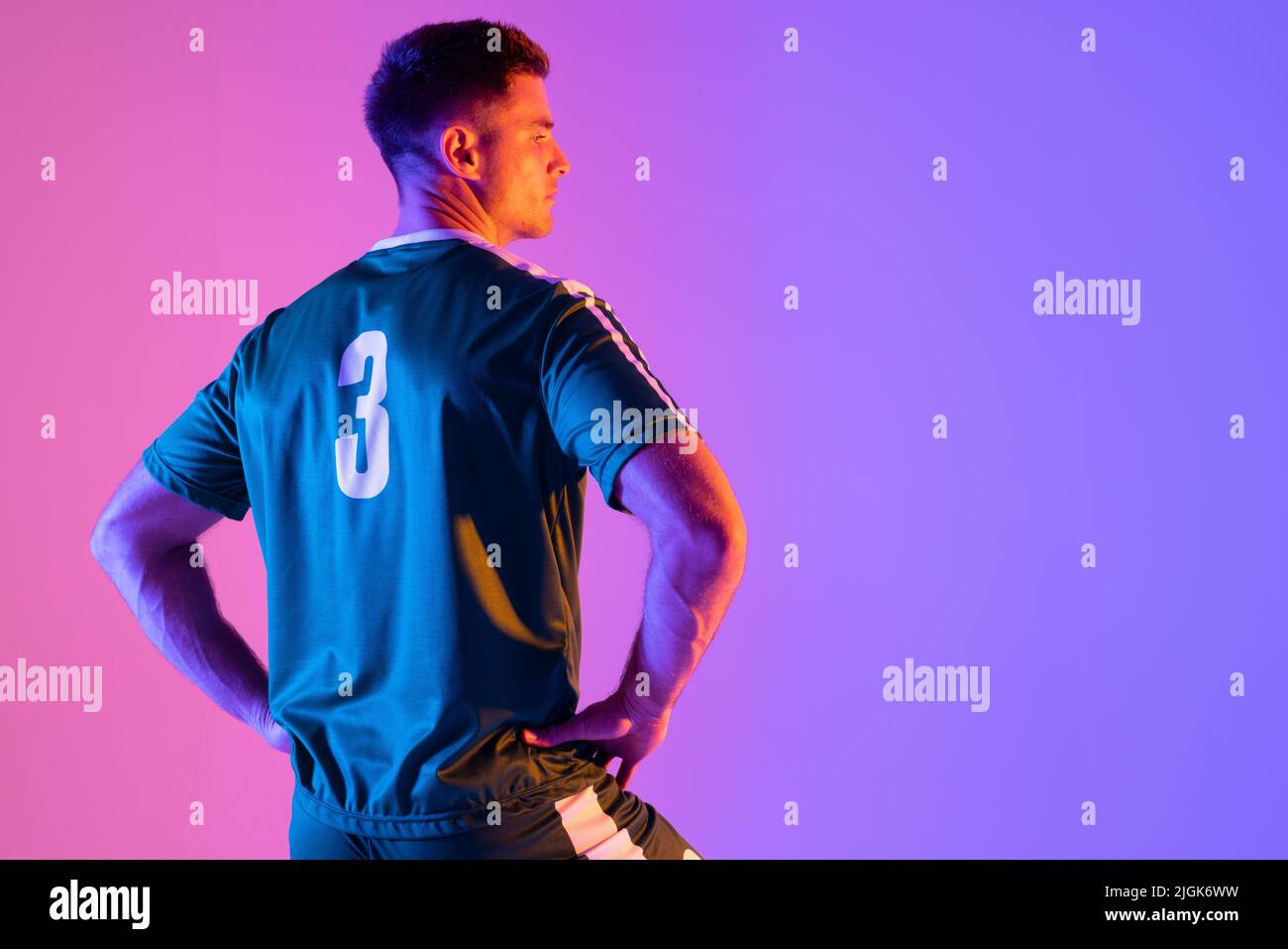 Caucasian male soccer player over neon pink lighting Stock Photo