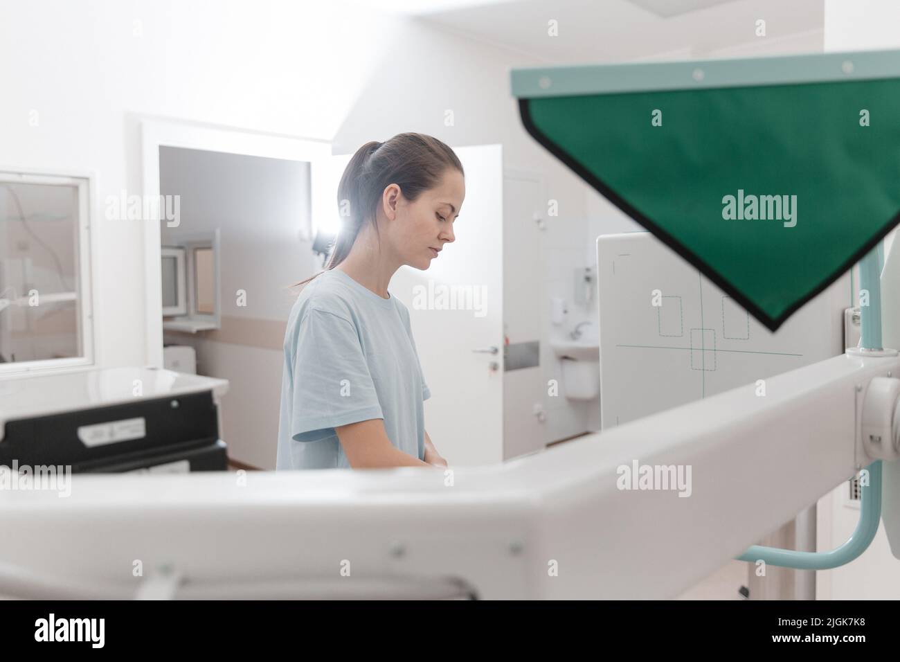 Hospital Radiology Room. Xray machine for fluorography. Doctor radiologist in gown adjusting the