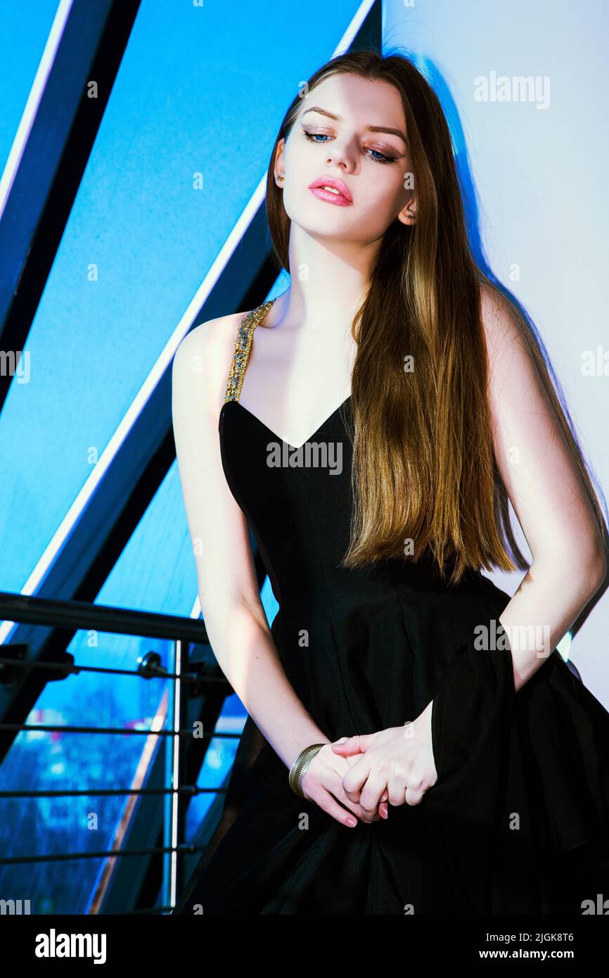 Pretty expressive brunette wearing only black clothes stands near a balcony railing Stock Photo