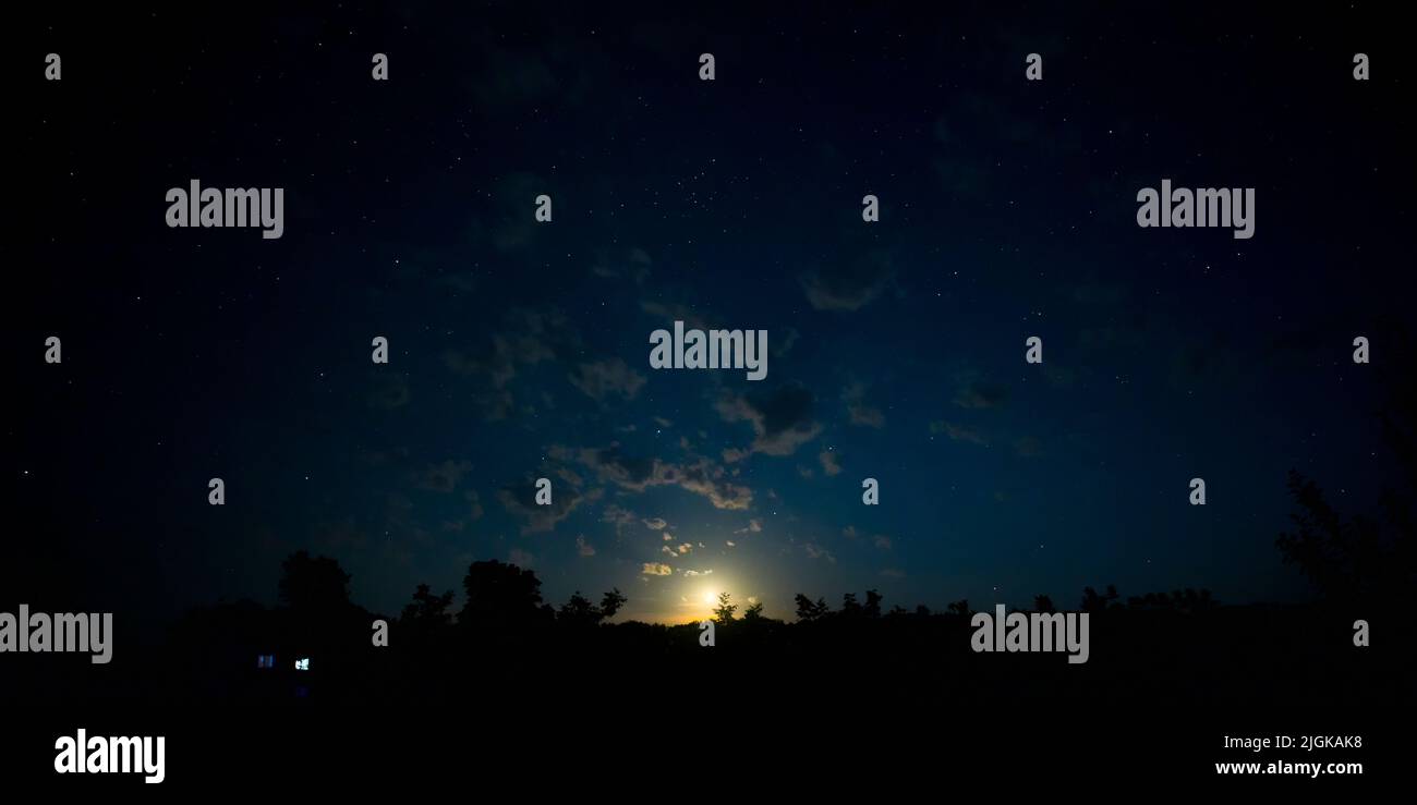 Moonset in the night sky with stars Stock Photo