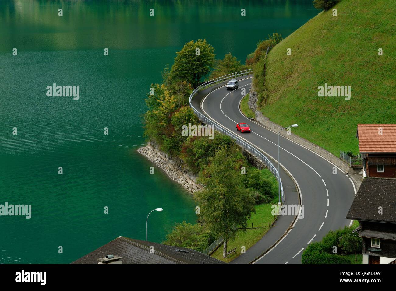 A car drive by the twisty road with a beautiful view. A lake in a mountain valley. Stock Photo
