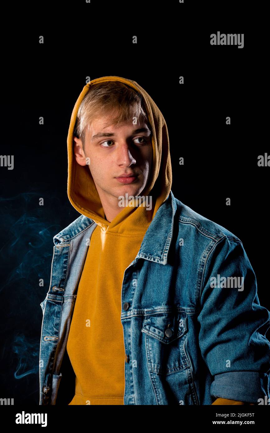 Studio fashion portrait of a handsome guy wearing jeans jacket and