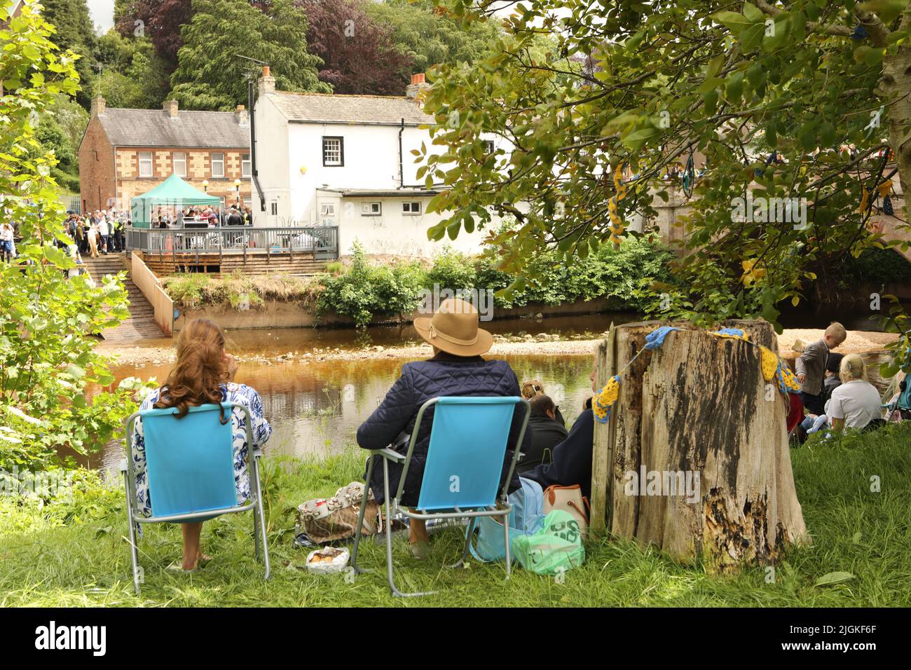 A couple sitting deckchairs on the banks of the River Eden, Appleby Horse Fair, Appleby in Westmorland, Cumbria Stock Photo