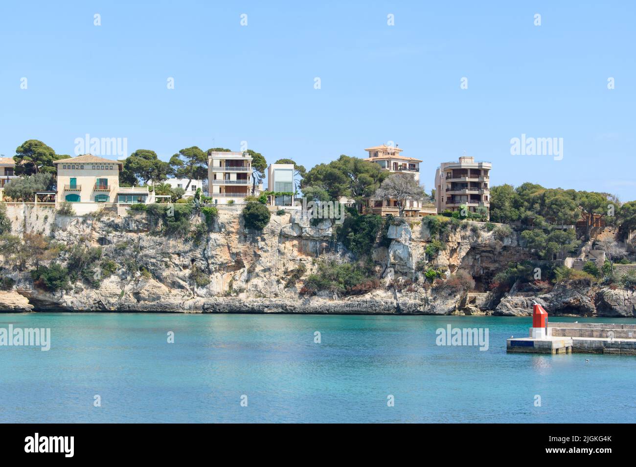 Houses on top of the coastal cliffs in Porto Cristo. Calm, turquoise sea water Stock Photo Alamy