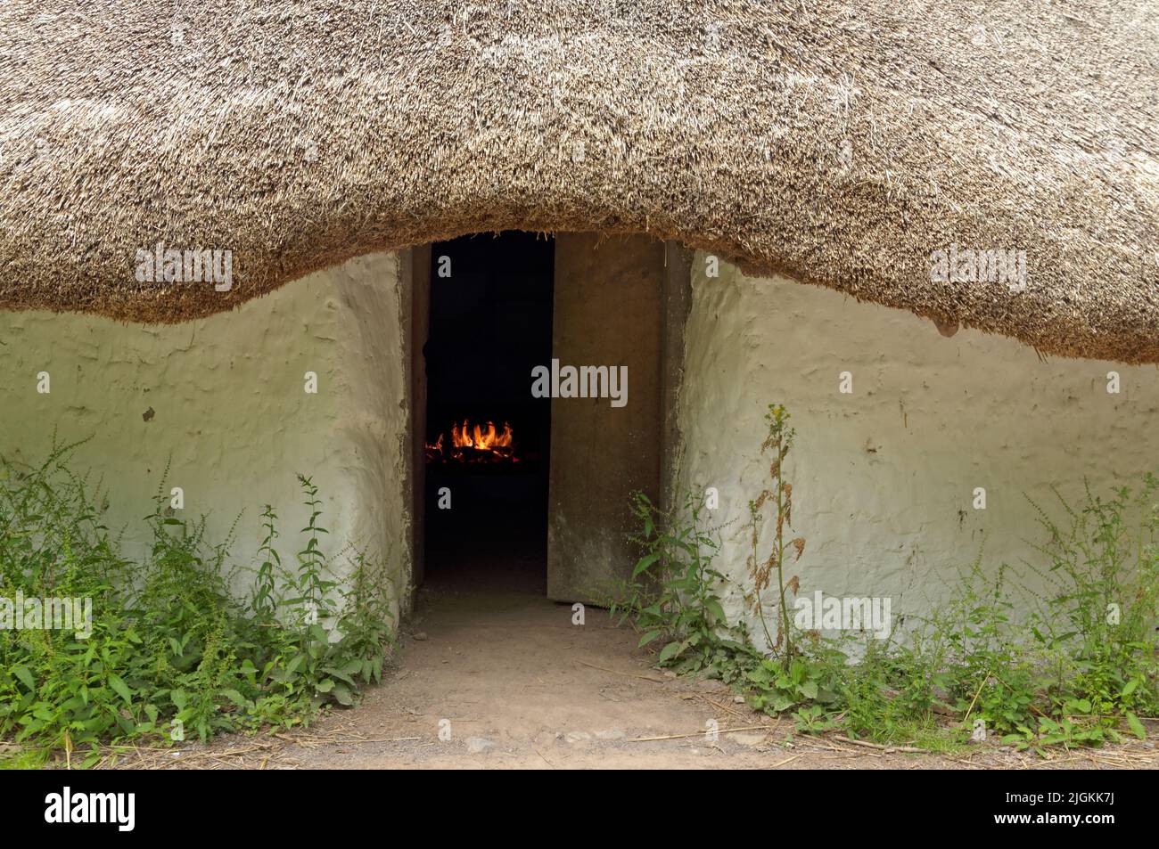 Bryn Eryr Iron Age Roundhouses. St Fagans Views. July 2022. Summer. A small fire burns inside. Stock Photo