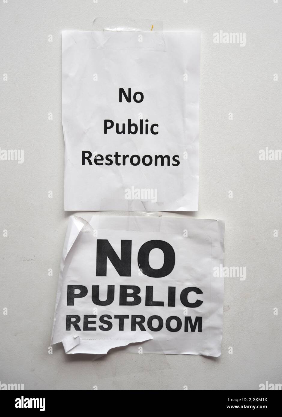 Signs taped on a restroom wall inform customers in a shopping complex in Santa Fe, New Mexico, that there are no public restrooms in the complex. Stock Photo