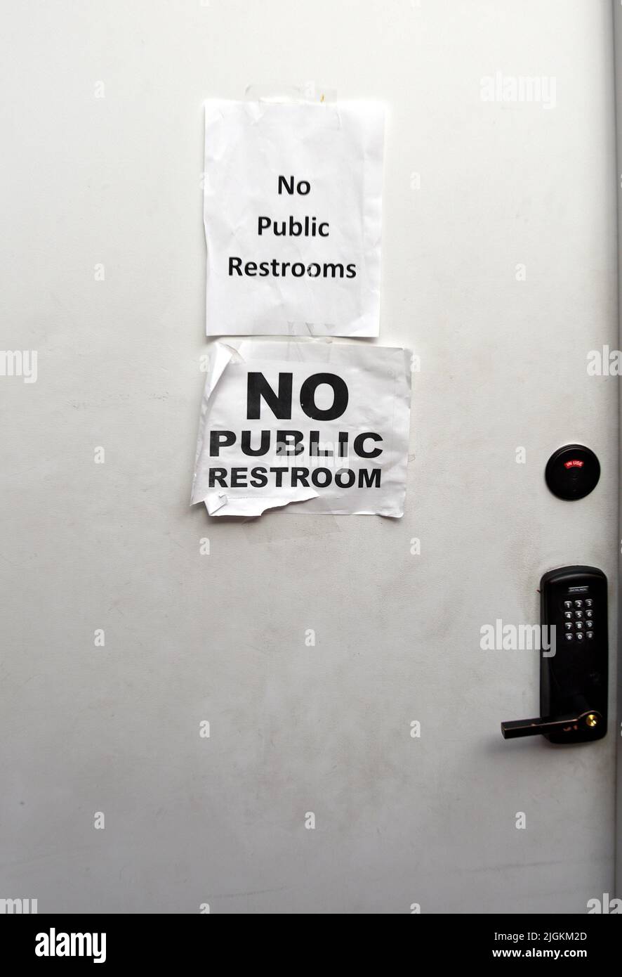 Signs taped on a restroom wall inform customers in a shopping complex in Santa Fe, New Mexico, that there are no public restrooms in the complex. Stock Photo