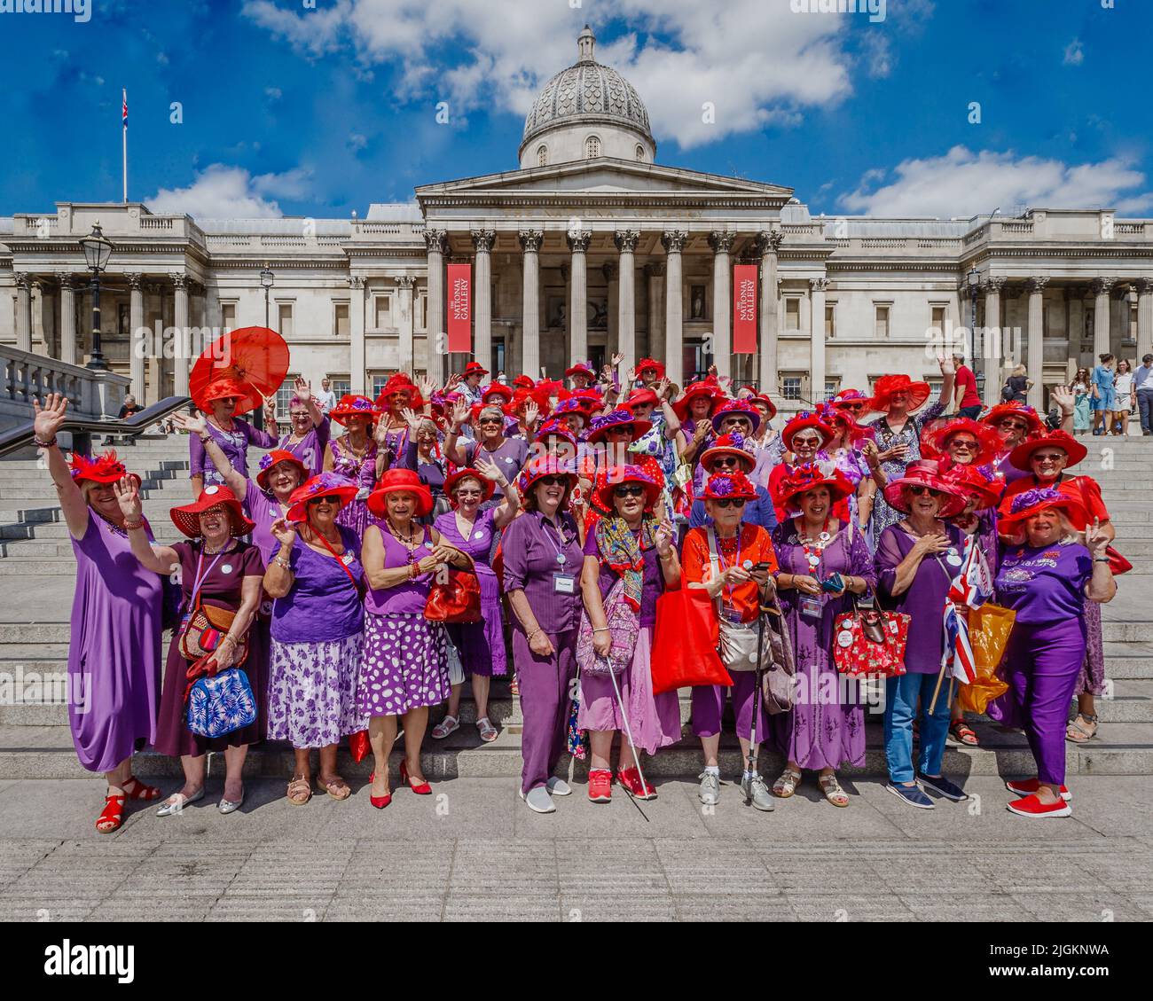 The Red Hatters meet, and pose for a photograph by the National Gallery