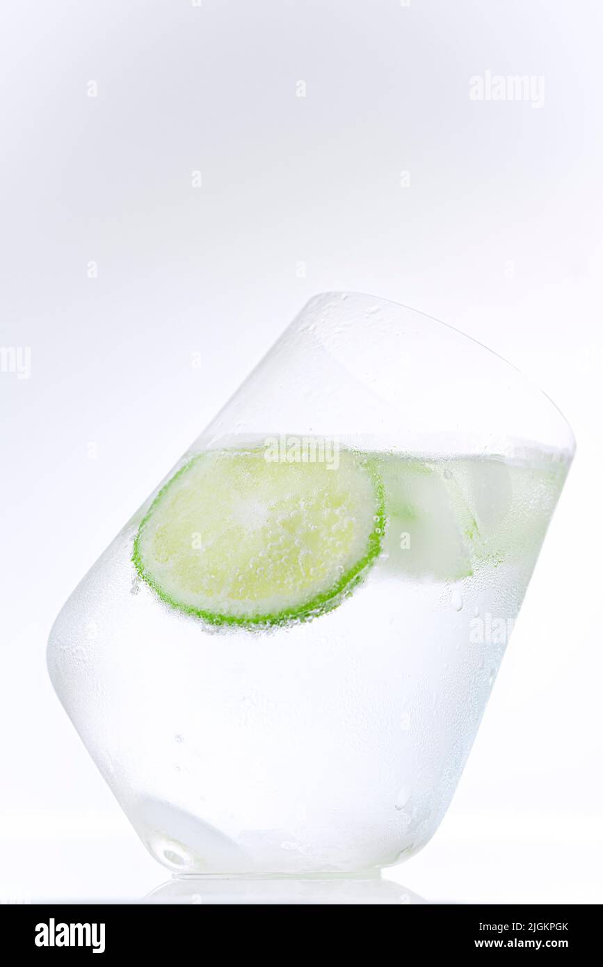 Cold mineral water with lime and cucumber slice on a white background, isolated Stock Photo