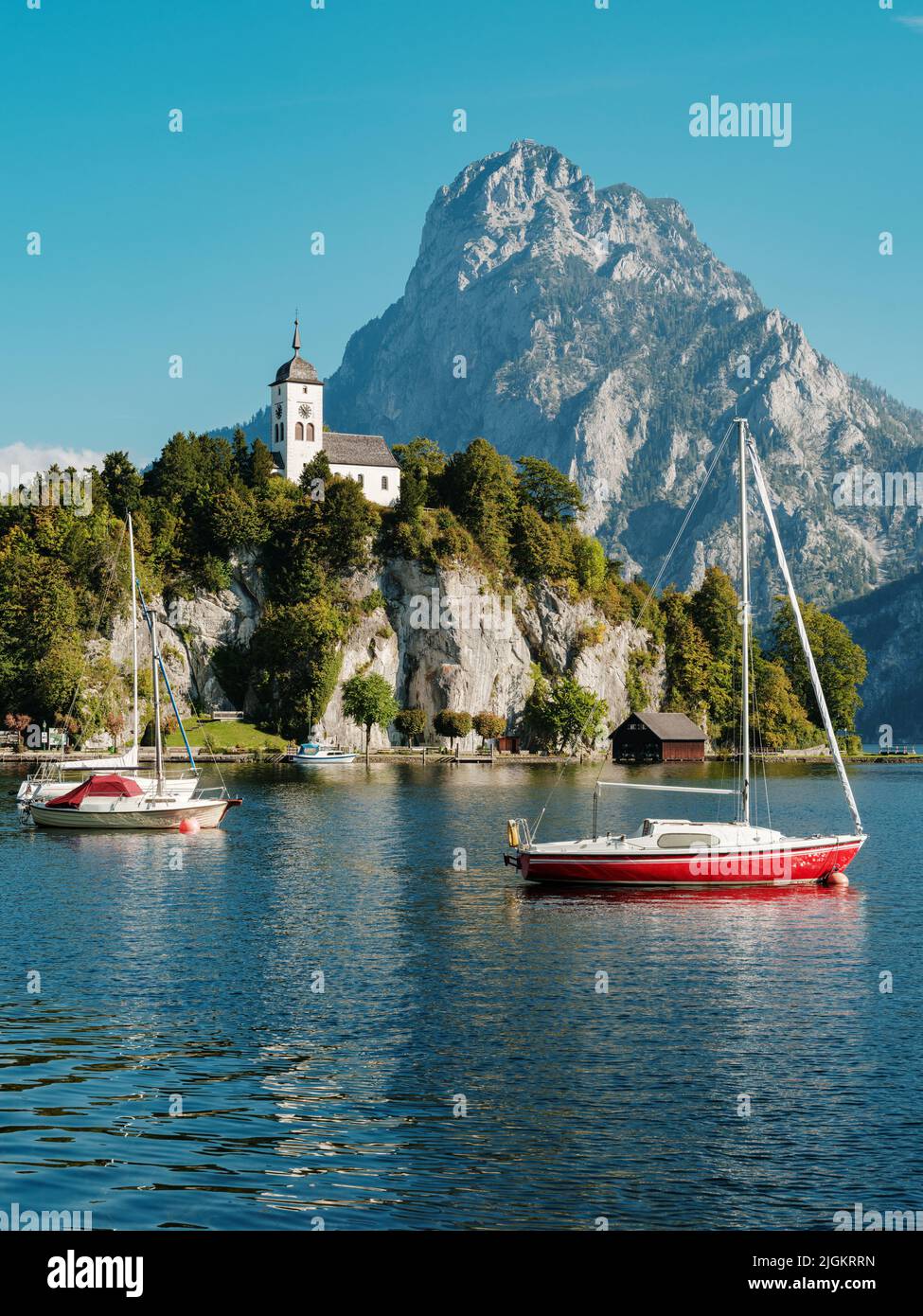 Scenic view on the perched Johannesberg Chapel in Austria, surrounded by mountains and the lake Traunsee Stock Photo