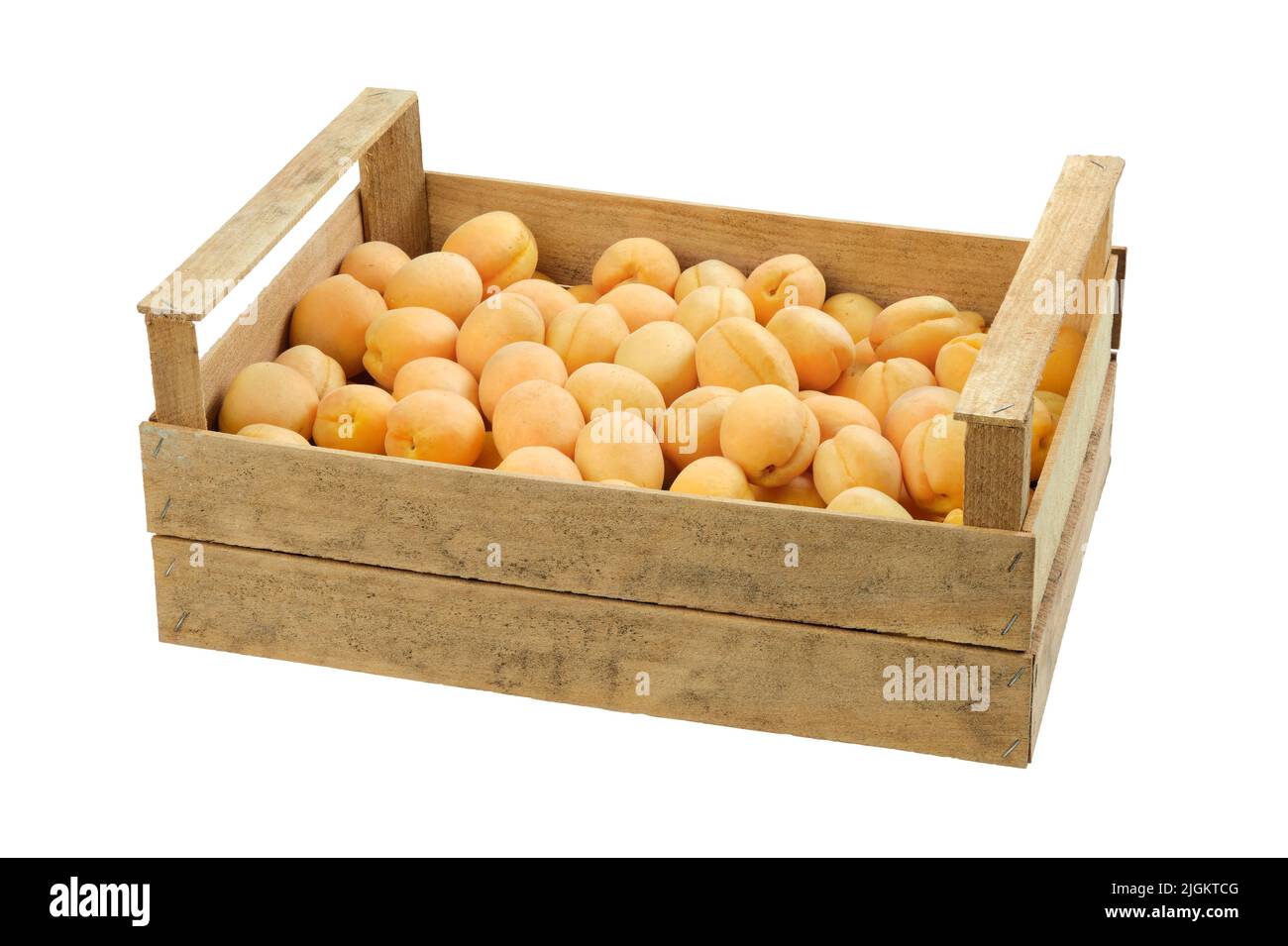 Wooden crate full of fresh ripe apricots, isolated on white background. Stock Photo
