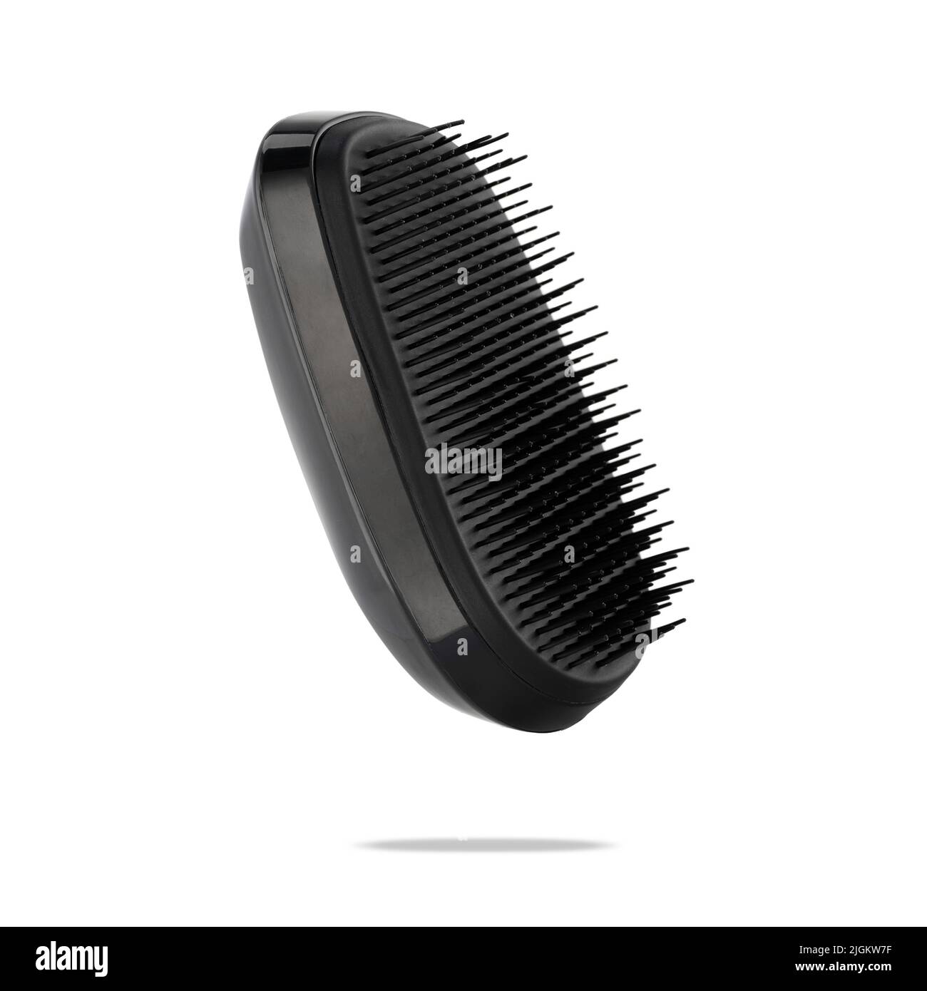 A detangler hairbrush float on white. A comb for detangling and caring for hair and scalp. Accessory for a lather shampoo and head skin massage. Stock Photo