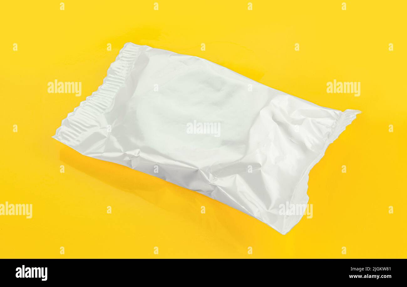 Silver foil dessert packaging isolated on yellow background Stock Photo