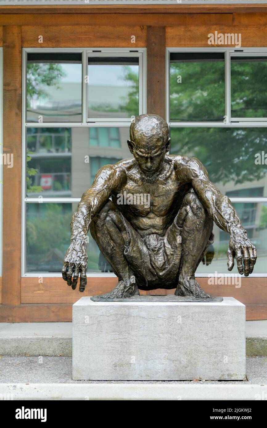 Bronze sculpture, by artist James Stewart.of squatting man,  called “Jeri”, Kitsilano,  Vancouver, British Columbia, Canada Stock Photo