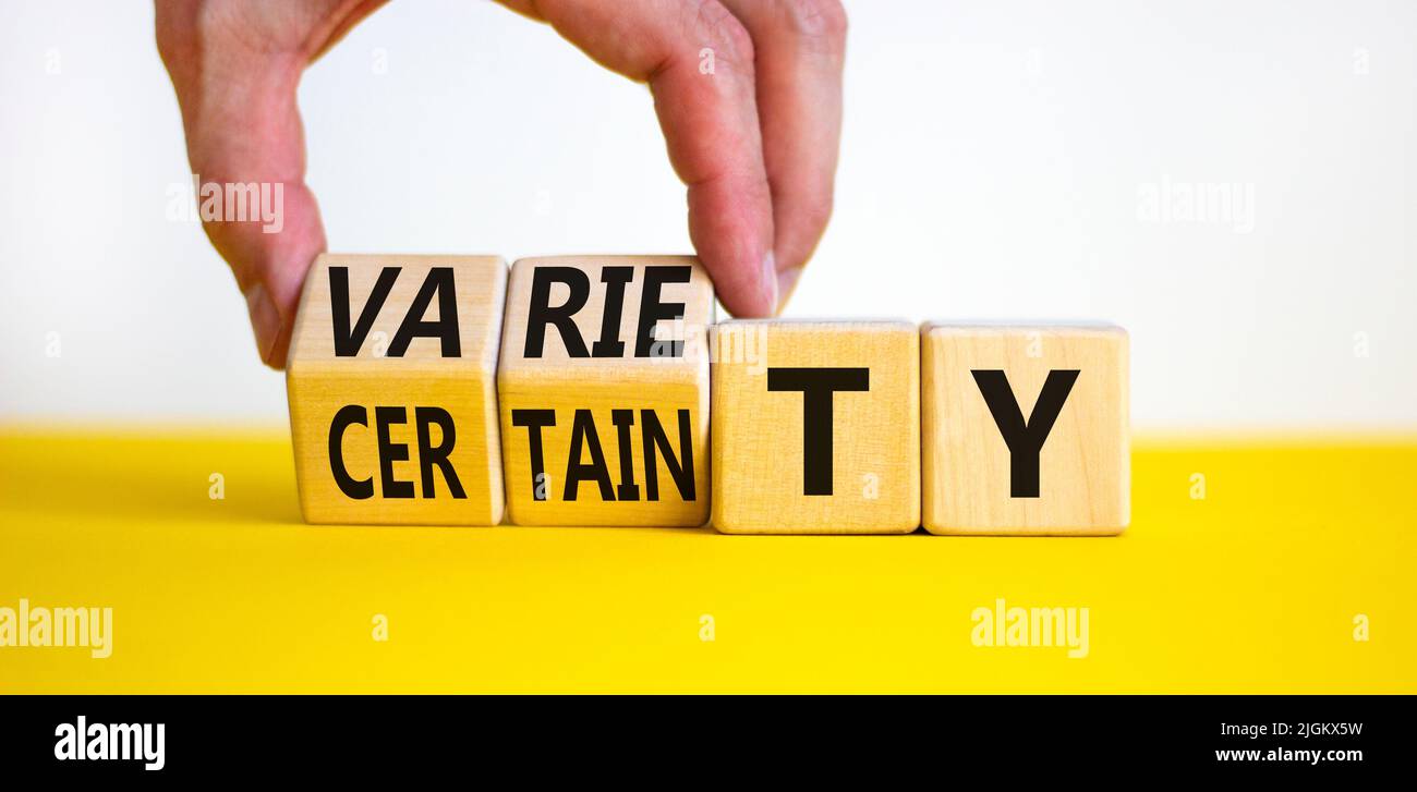 Variety or certainty symbol. Concept words Variety or certainty on wooden cubes. Businessman hand. Beautiful yellow table white background. Business v Stock Photo
