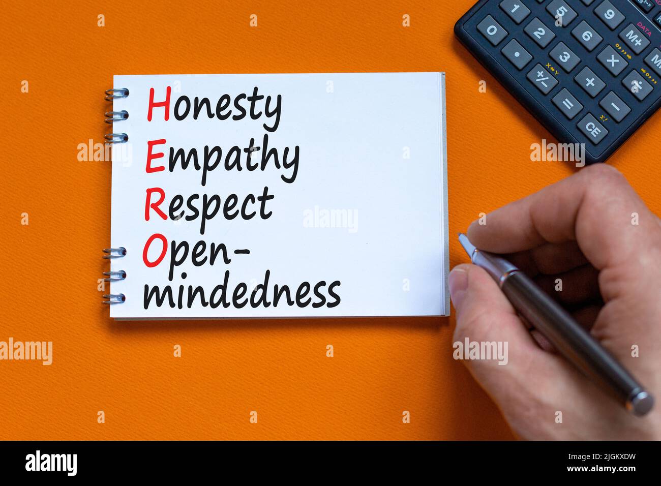 HERO honesty empathy respect open-mindedness symbol. Concept words HERO honesty empathy respect open-mindedness on the note on orange background. HERO Stock Photo