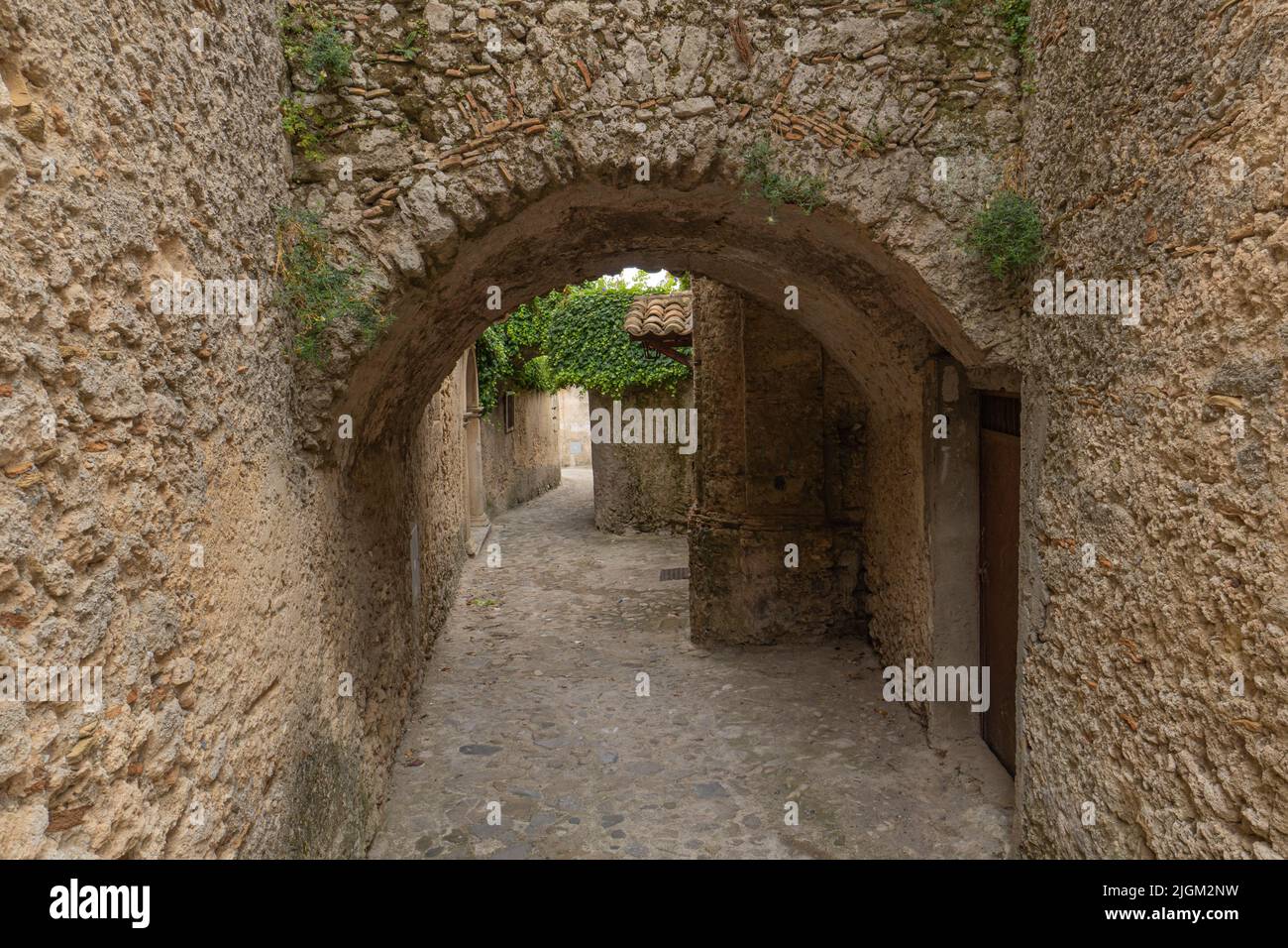 Old stone walls with a round arch in an Italian village Stock Photo