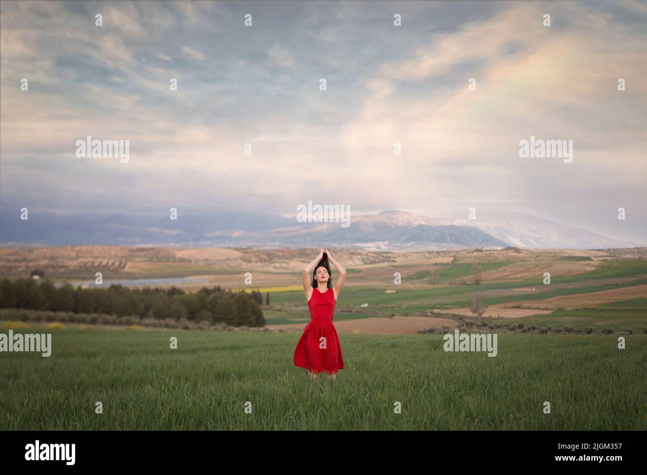 Girl in red dress in the field at sunset Stock Photo - Alamy
