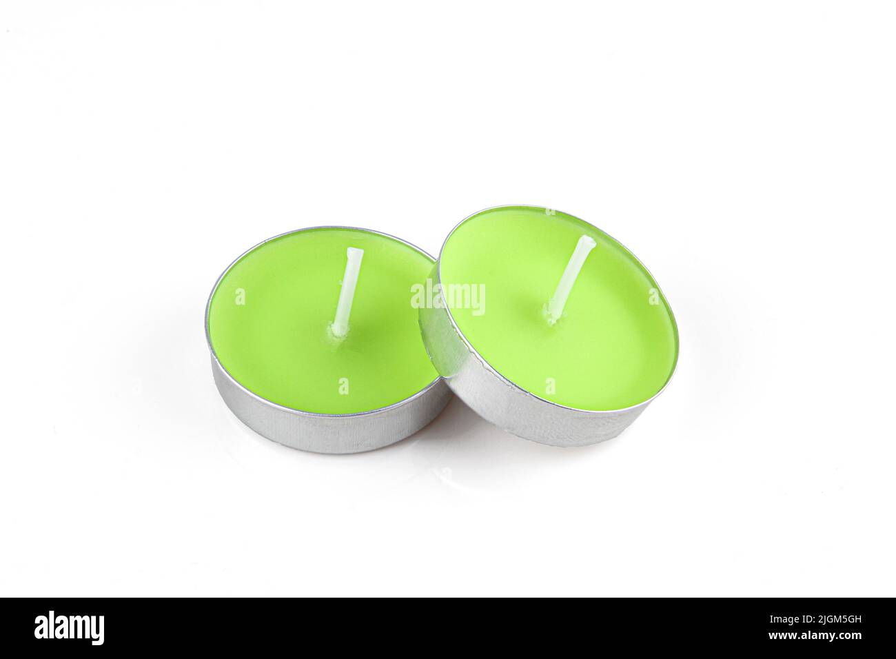 Small unused wax candles isolated on white background. Green decorative object Stock Photo