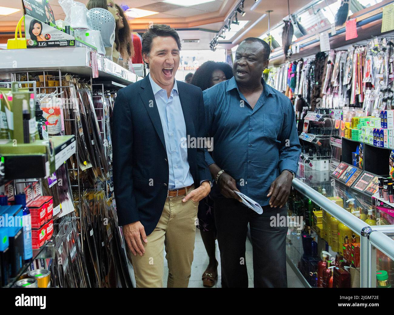 Prime Minister Justin Trudeau laughs as visits a local store in his