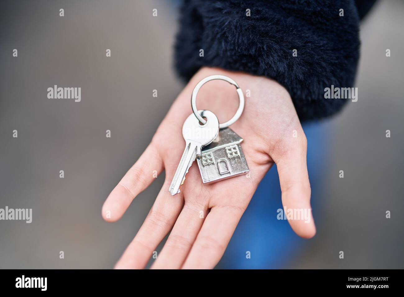 Young woman holding key of new home at street Stock Photo - Alamy