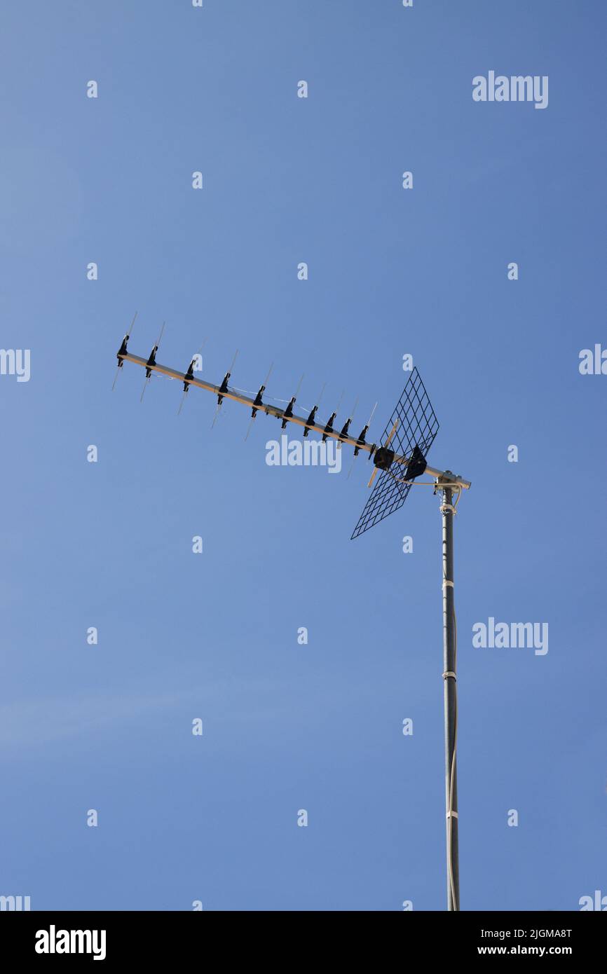 Yagi-Uda type television antenna, directional for the reception of digital terrestrial television, with blue sky in the background Stock Photo