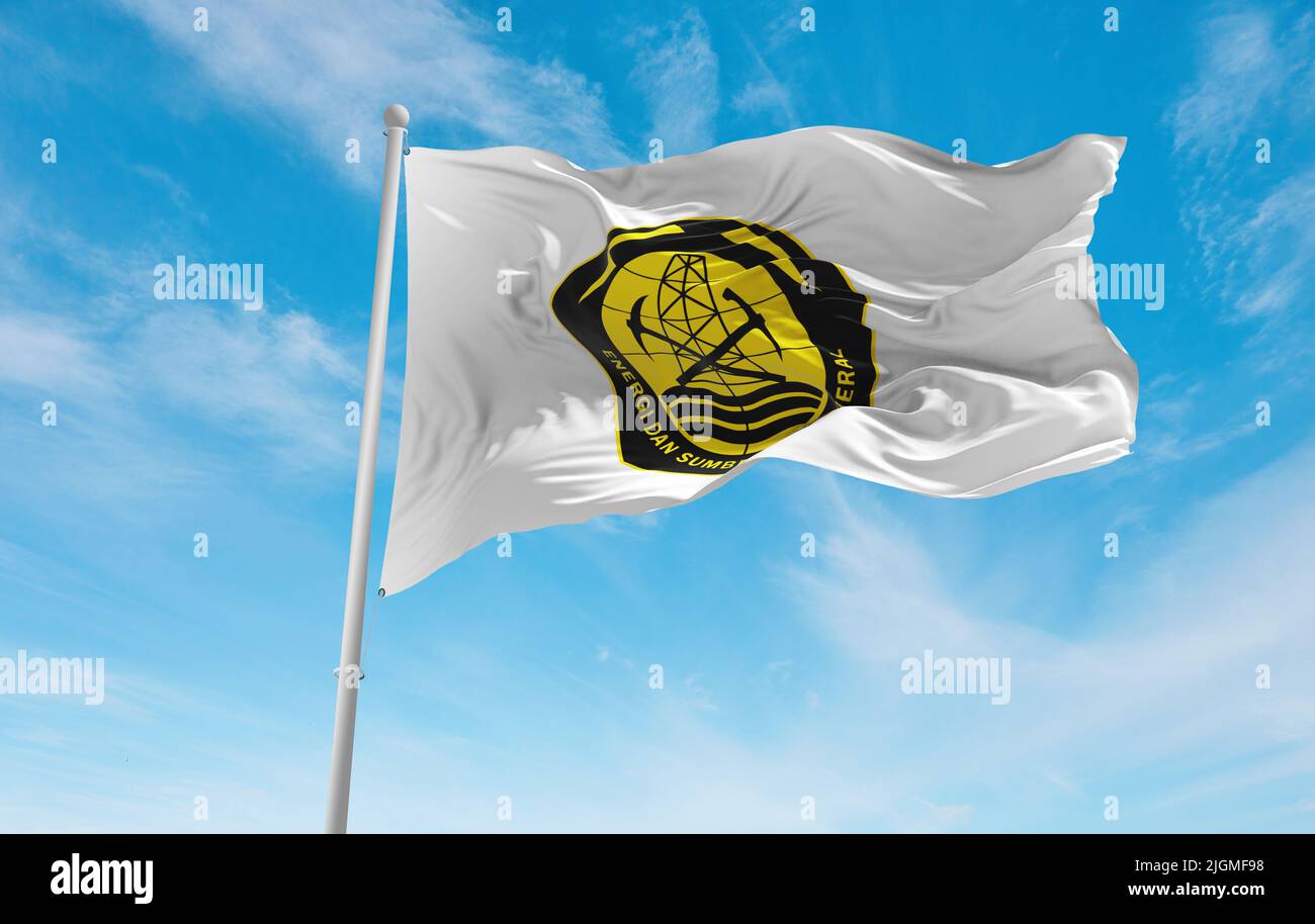 official flag of Ministry of Energy and Mineral Resources Indonesia at cloudy sky background, panoramic view. Indonesian travel and patriot concept. c Stock Photo