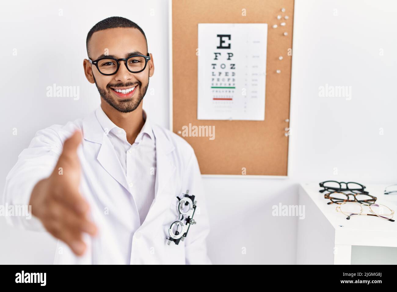 African american optician man standing by eyesight test smiling ...