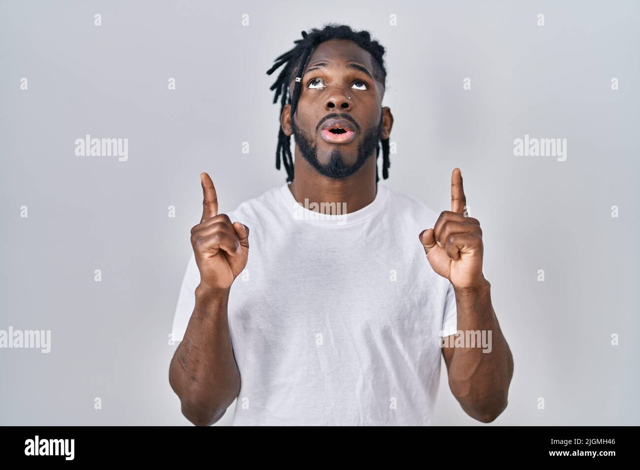 African man with dreadlocks wearing casual t shirt over white ...