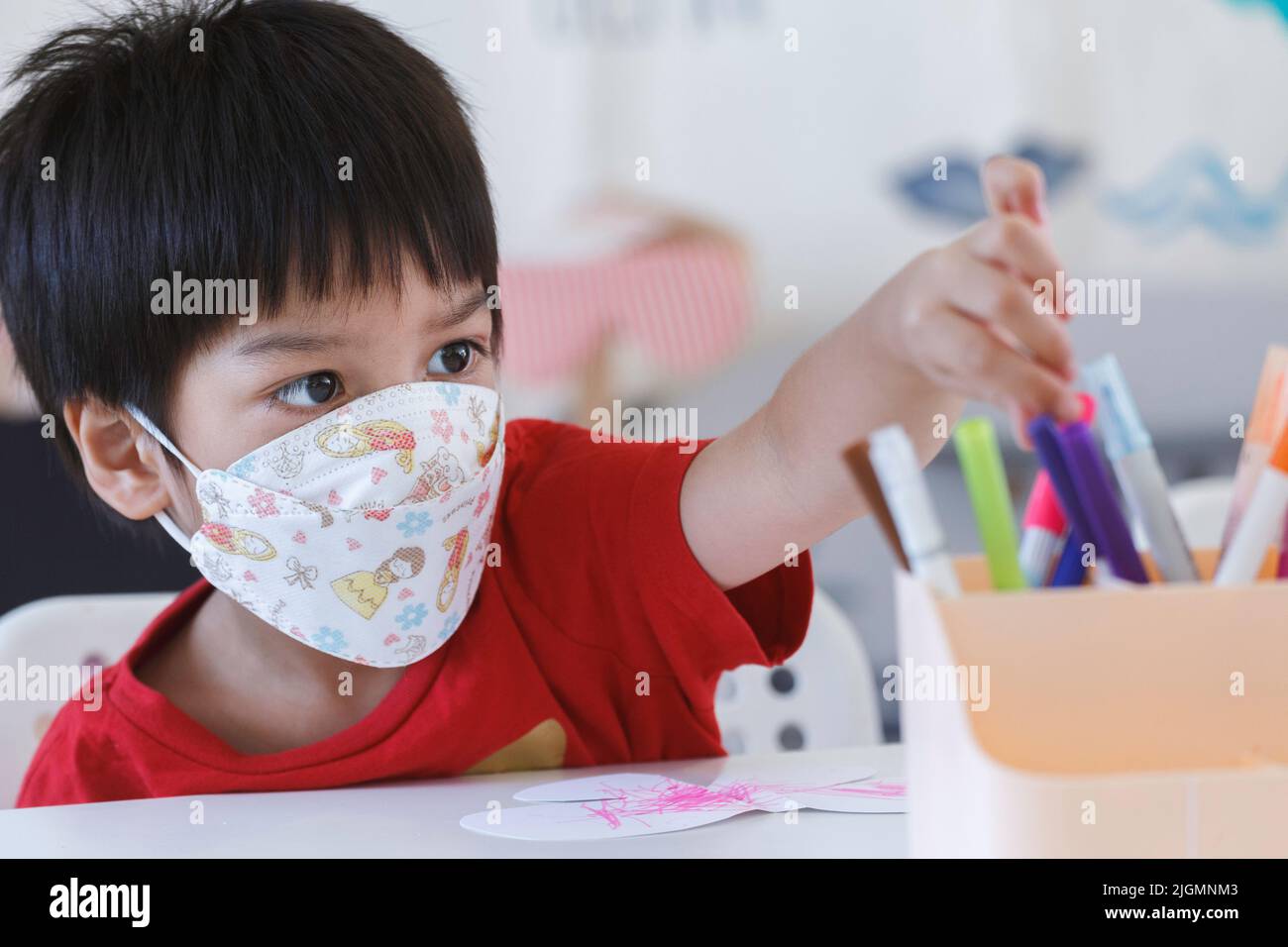 student boy chooching color pen to drawing and painting in nursery classroom at kindergarten school. preschool children education. Stock Photo