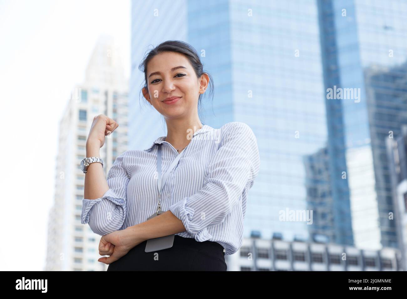 portrait of confident happy smiling young asian businesswoman standing outside the office in the city with building background and copy space. busines Stock Photo