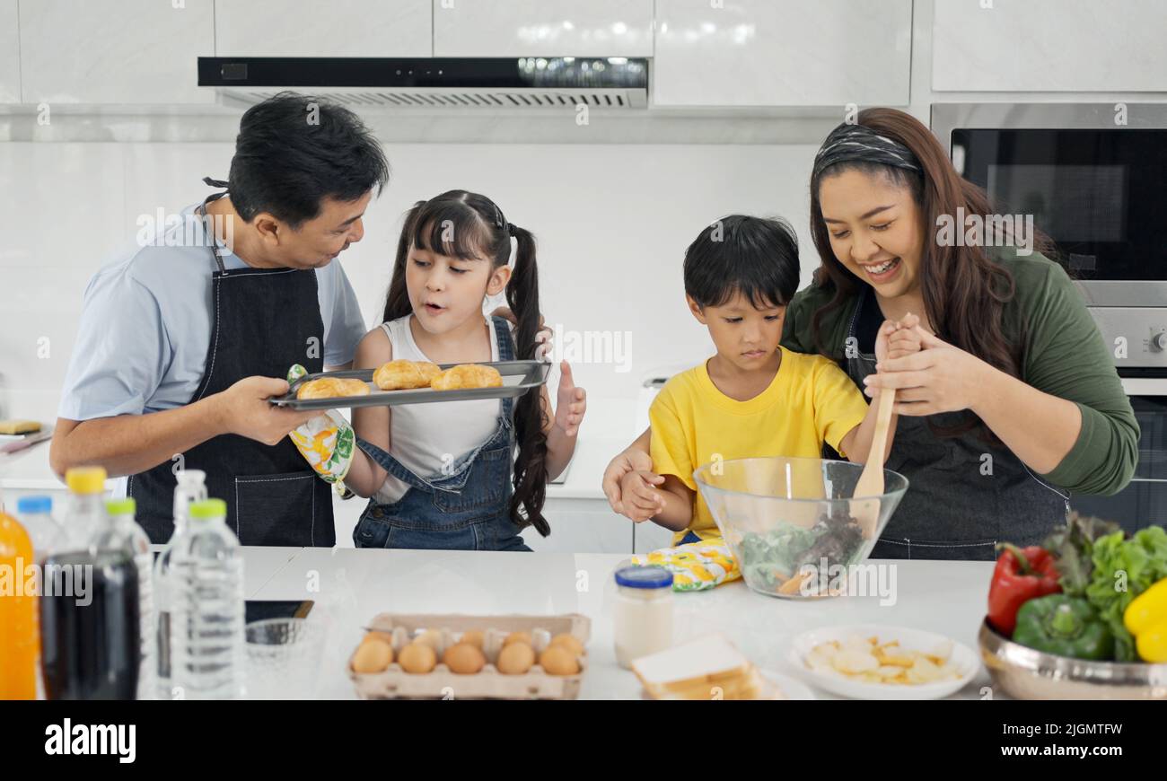 Happy asian family enjoy playing and cooking in the home kitchen. Stock Photo