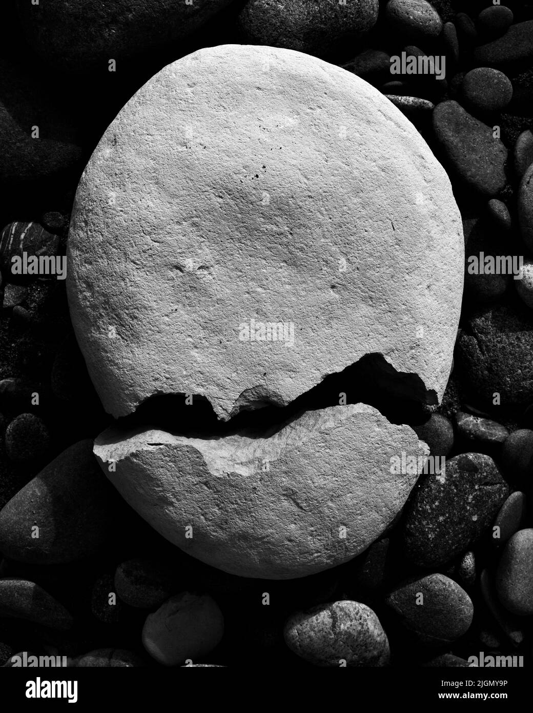 A cracked rock looking like a scary face with a toothless crooked grin or snarl. Stock Photo