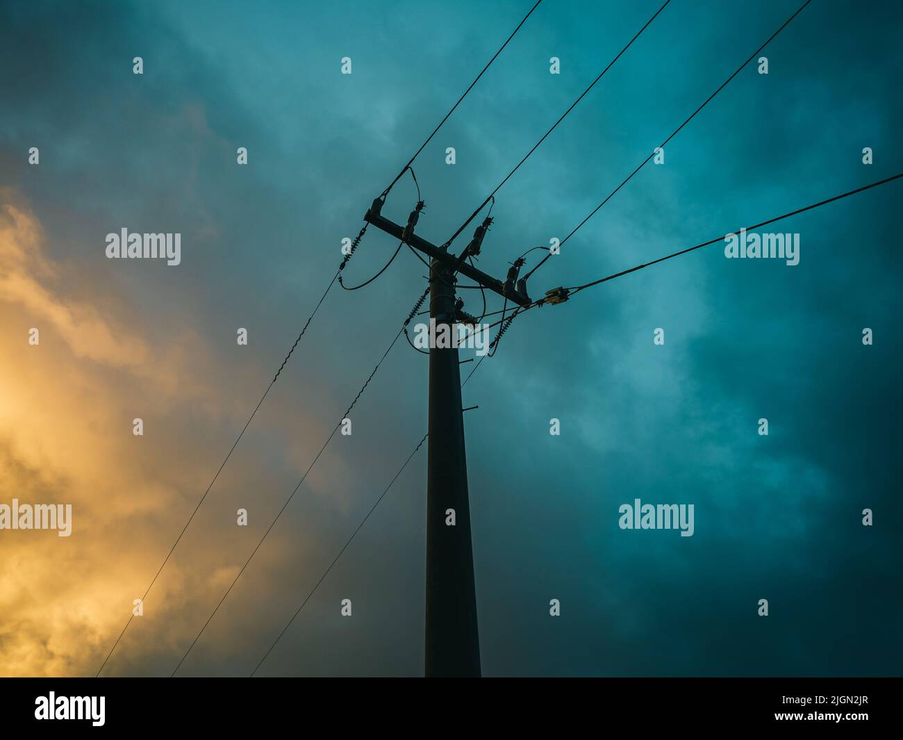 Electrical powerlines with cloudy sky backdrop Stock Photo