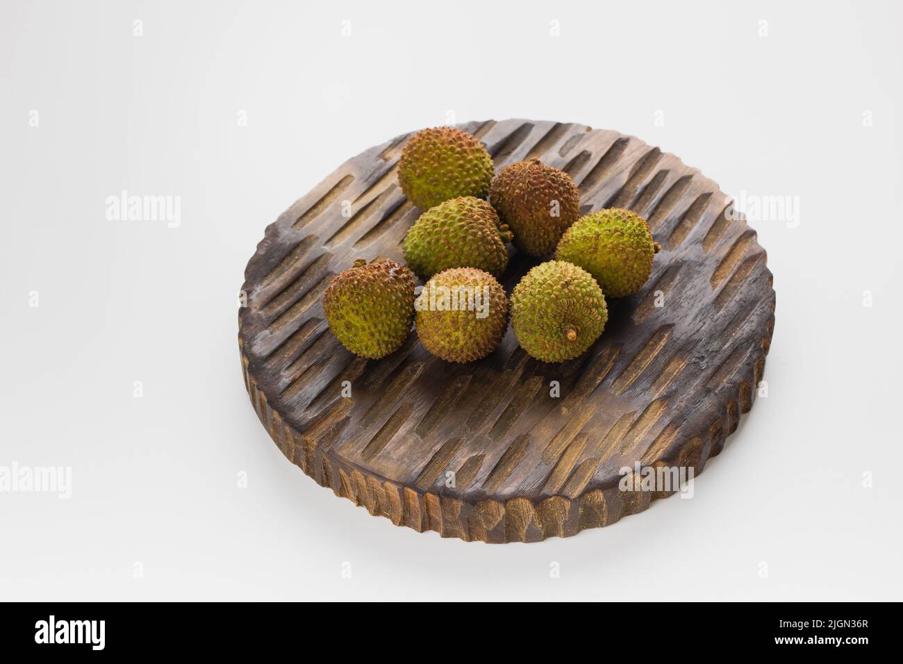 Fresh organic lychee in wooden rustic tray on white background Stock Photo