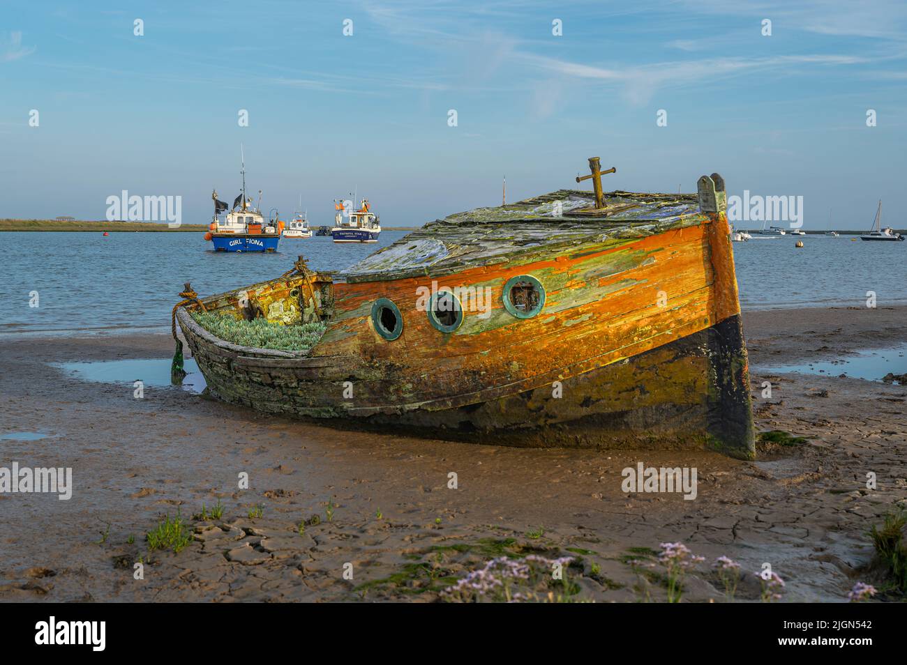An old boat moored on the mud and disused on the river Alde at Orford in Suffolk, UK Stock Photo