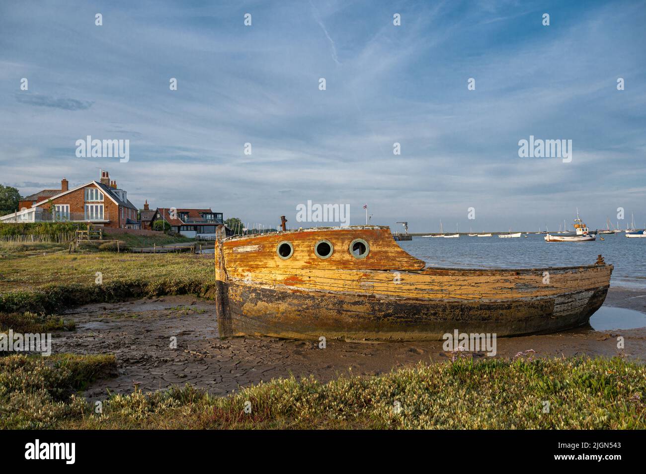 An old boat moored on the mud and disused on the river Alde at Orford in Suffolk, UK Stock Photo