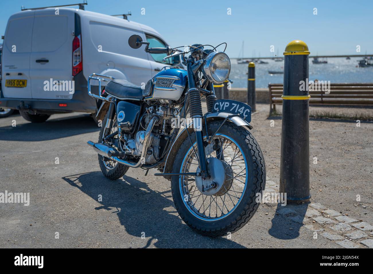 A Classic Triumph motorbike parked on the quayside at Orford in Suffolk, UK Stock Photo