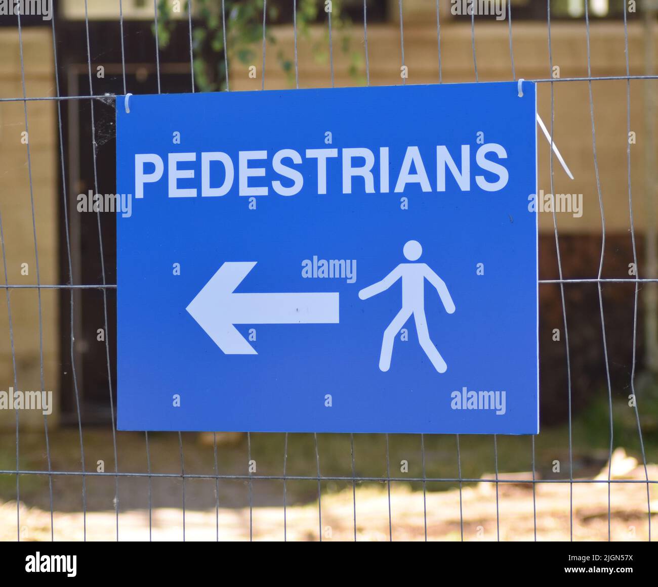 Sign on the fence at a building site showing the route for pedestrians. Stock Photo