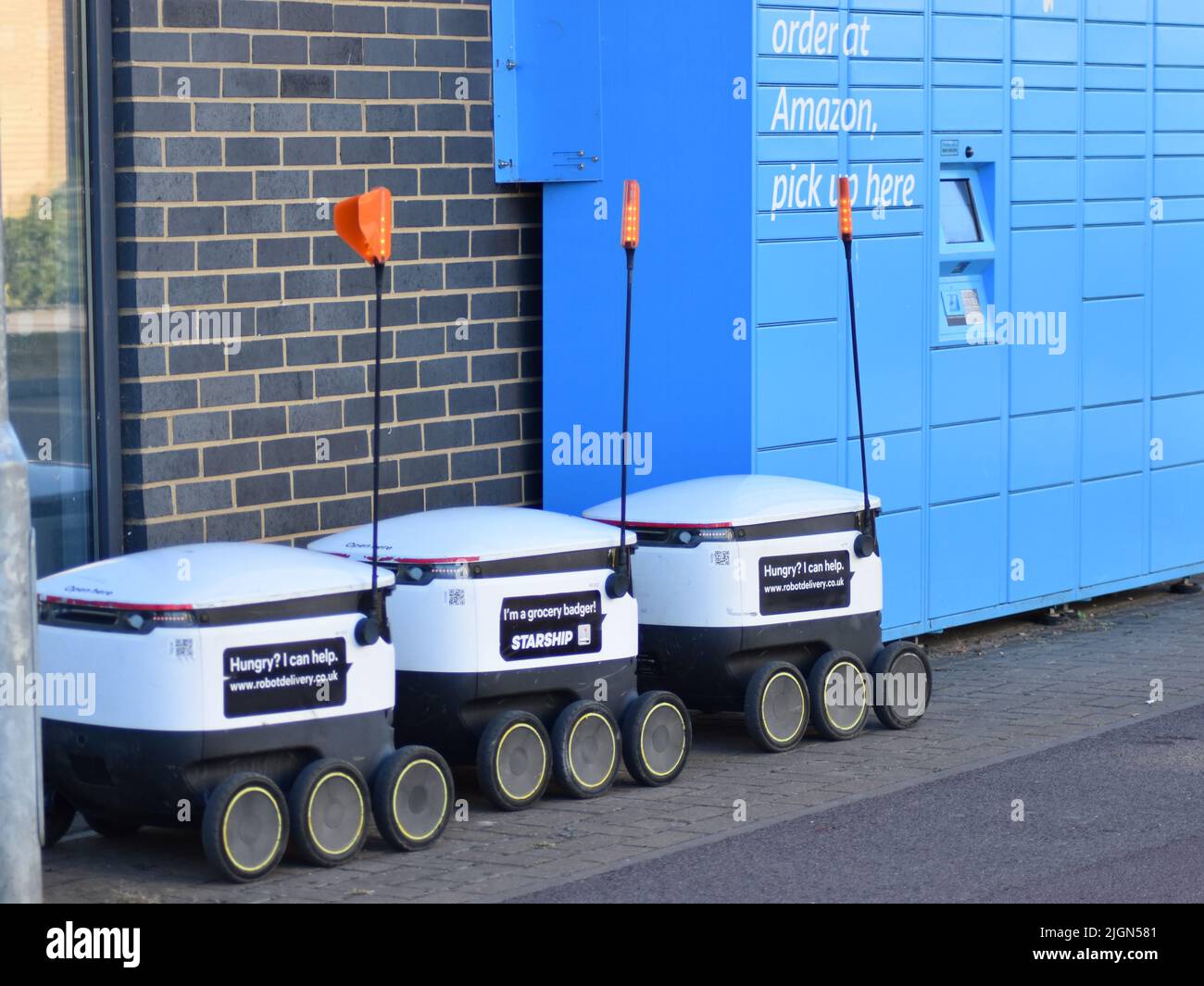Starship delivery robots waiting next to an Amazon locker. Stock Photo