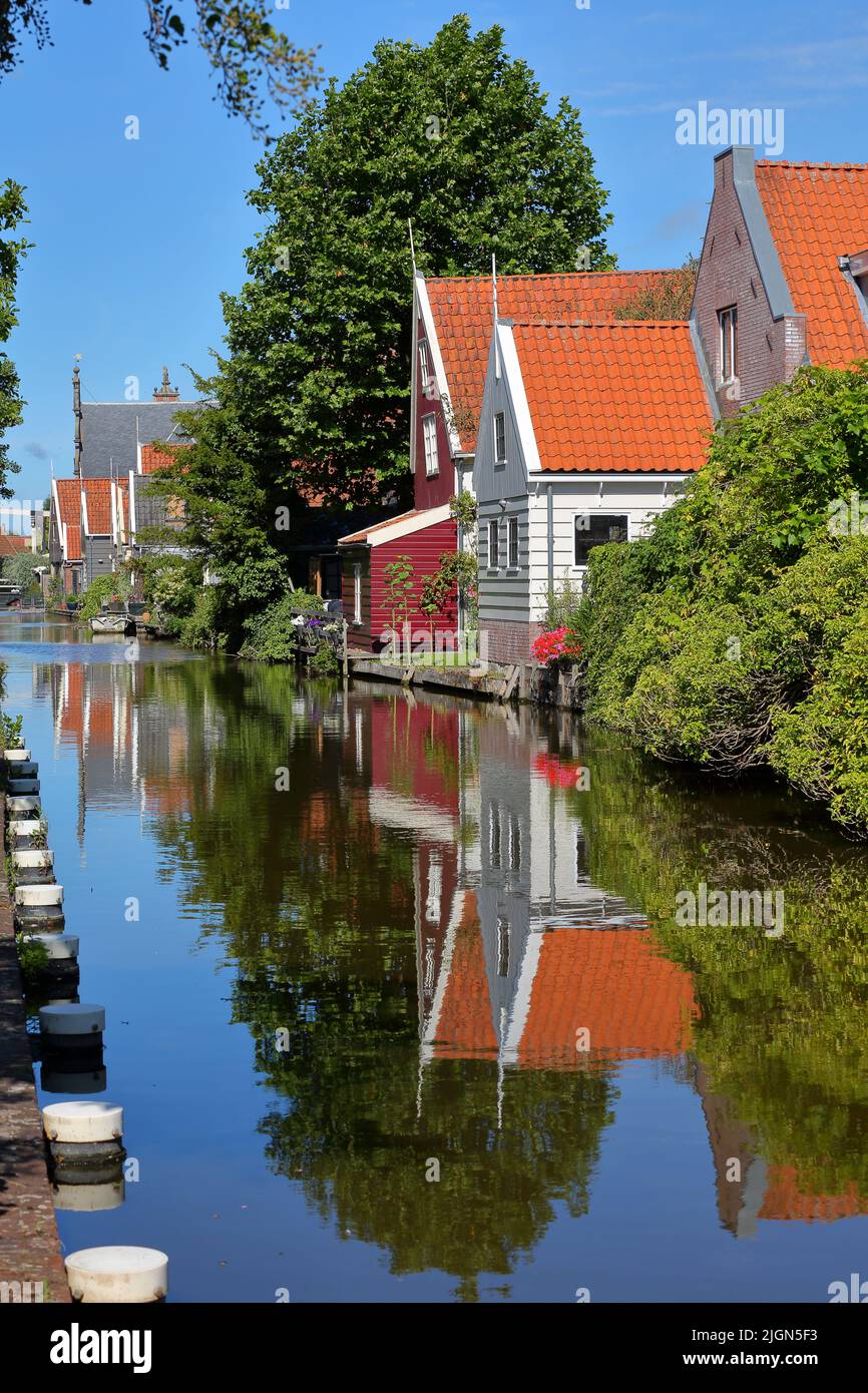 Colorful and historic house facades in De Rijp, Alkmaar, North Holland, Netherlands, reflected on a canal Stock Photo