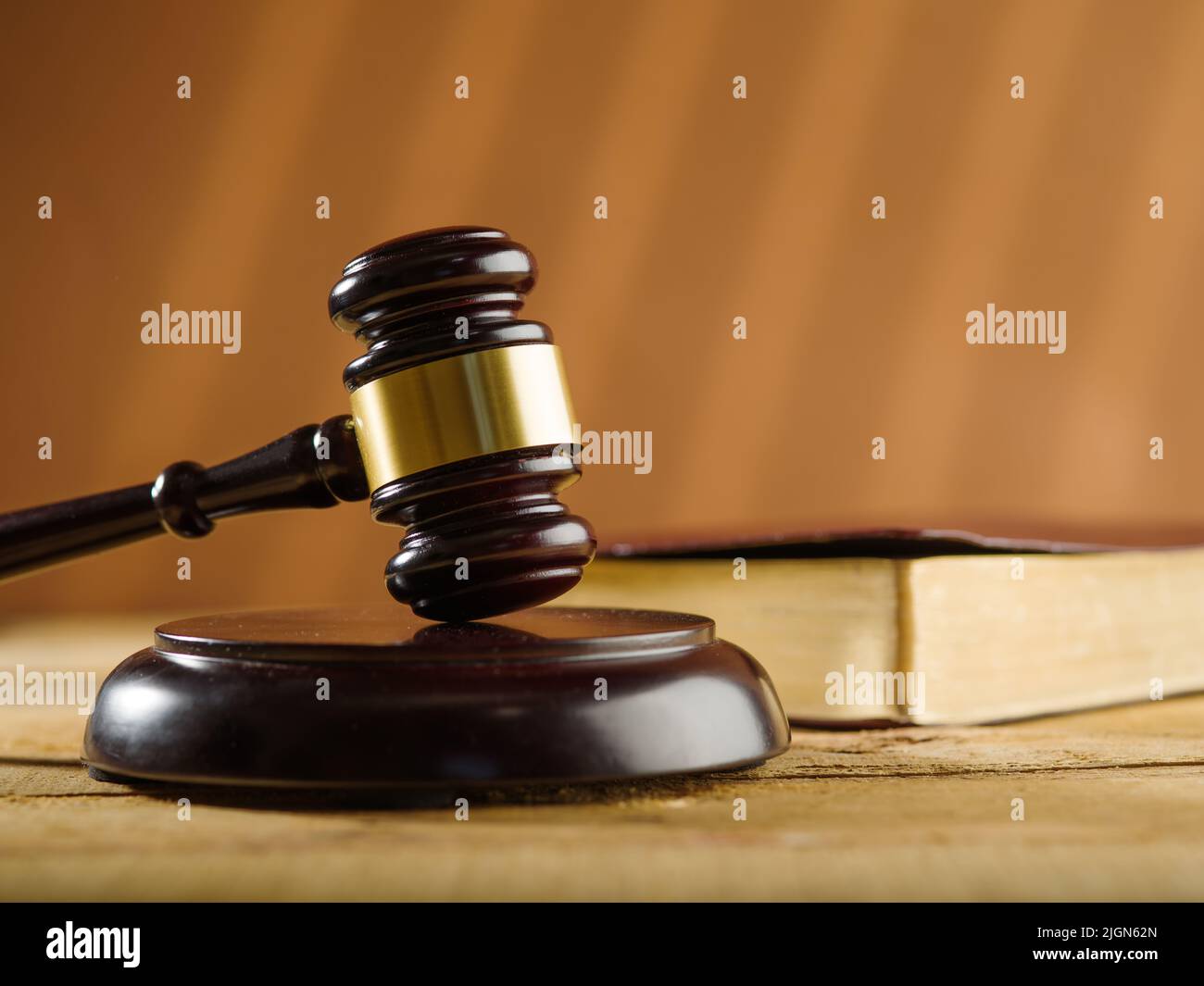 Wooden judge's gavel and a book on a table on a beige background ...