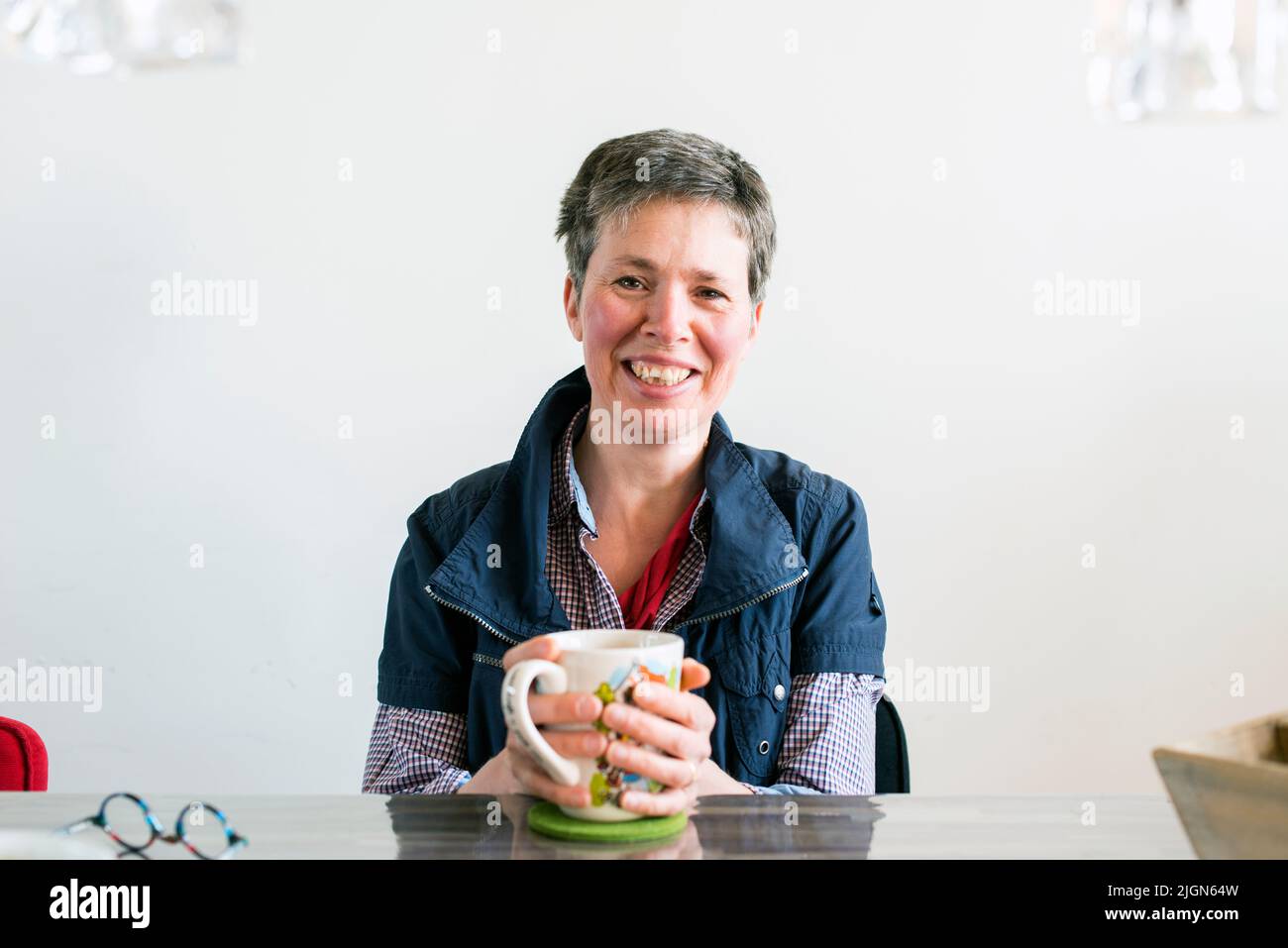 Tilburg, Netherlands. Mid adult caucasian woman, having multiple sclerosis or MS for over a decade, dealing with her disease by taking in healthy liquids and tea. Stock Photo