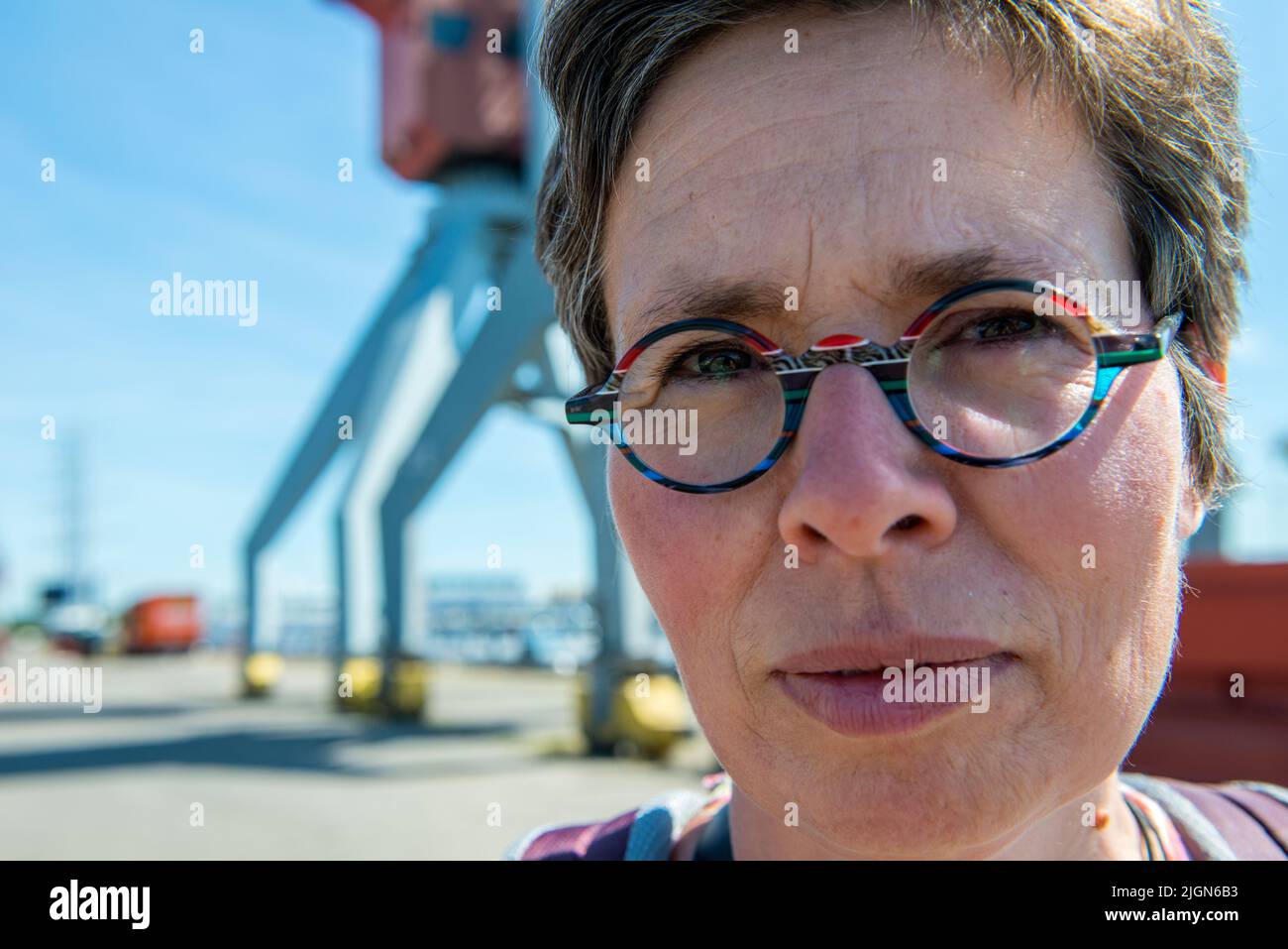Rotterdam, Netherlands. Portrait of a mature adult woman visiting a fruit terminal inside Port of Rotterdam for a summer day stroll. Stock Photo