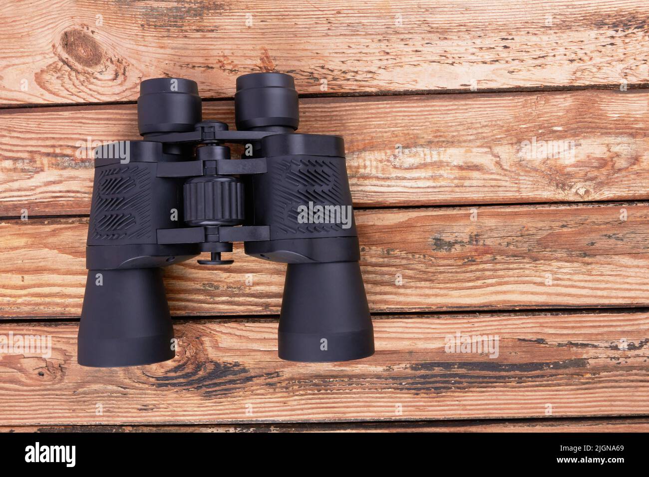 Black binoculars on a wooden surface Stock Photo
